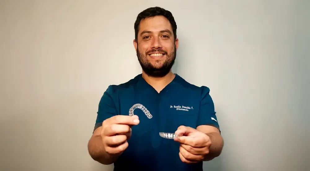 Dr. Bastián Arancibia, ortodoncista de Zagurt, mostrando alineadores dentales transparentes